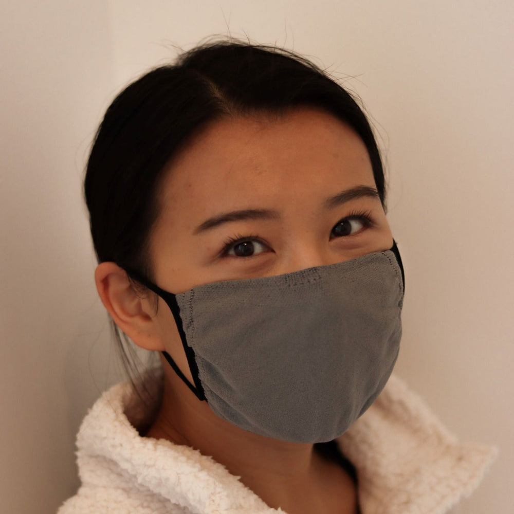 
                  
                    Woman wearing grey triple-layer reusable mask
                  
                