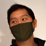 Man wearing olive green triple-layer reusable mask